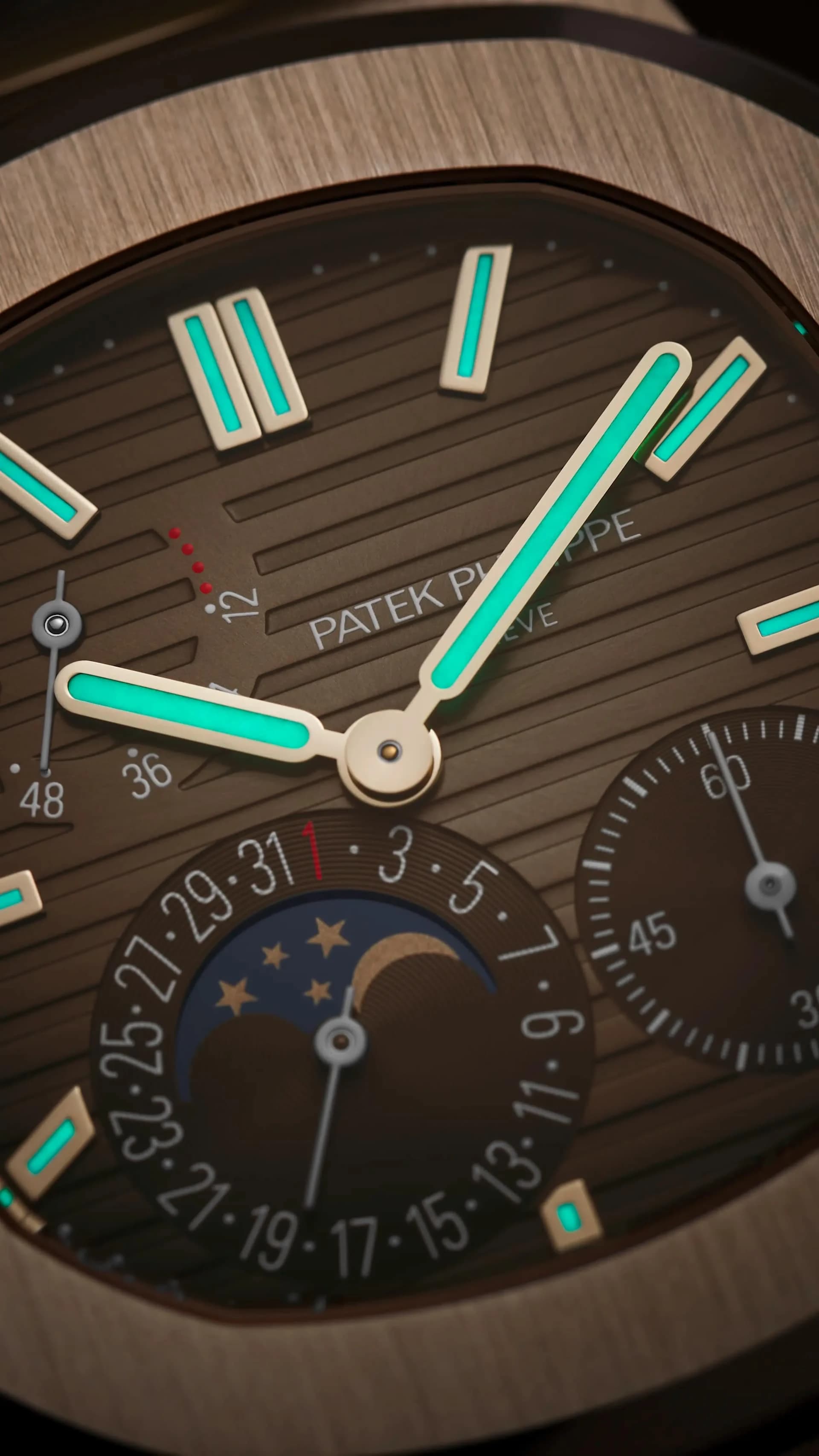 macro de la esfera marrón con índices luminiscentes turquesa, indicador de fase lunar y calendario, firma Patek Philippe Geneve visible