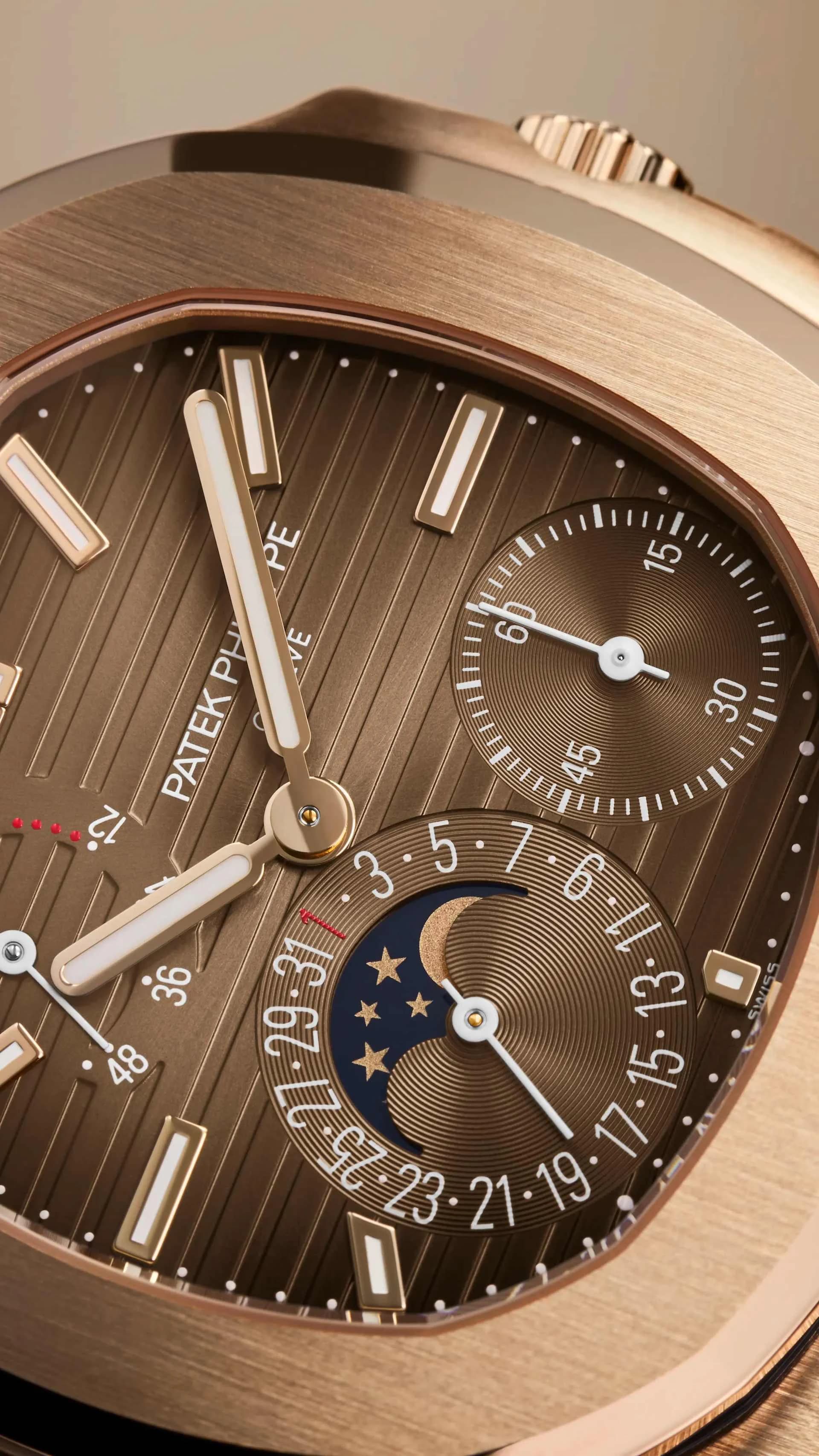 primer plano de la esfera marrón de un reloj con contador de segundos, indicador de fase lunar con estrellas y luna dorada, y escala de fechas circundante