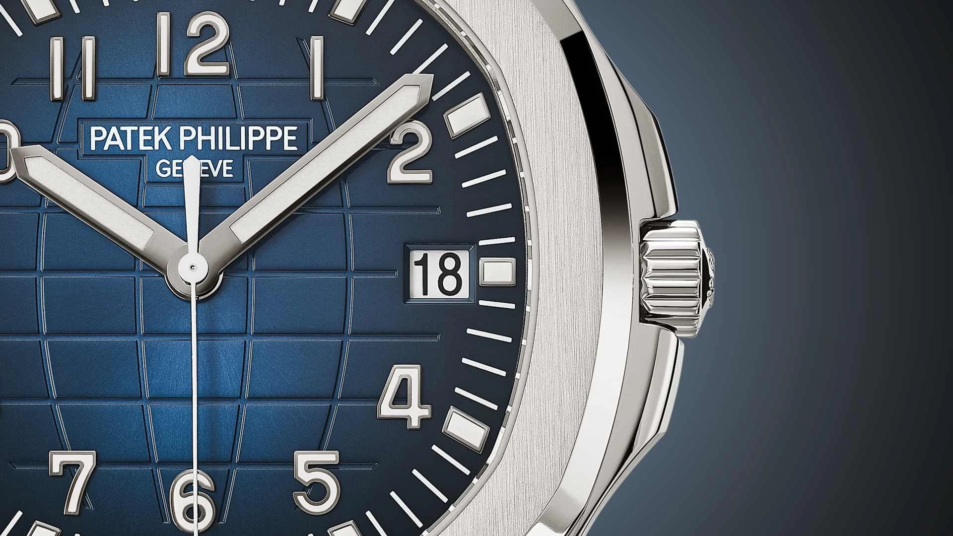 primer plano de la esfera azul con patrón de cuadrícula, corona y caja de acero de un reloj Patek Philippe con ventana de fecha en 18