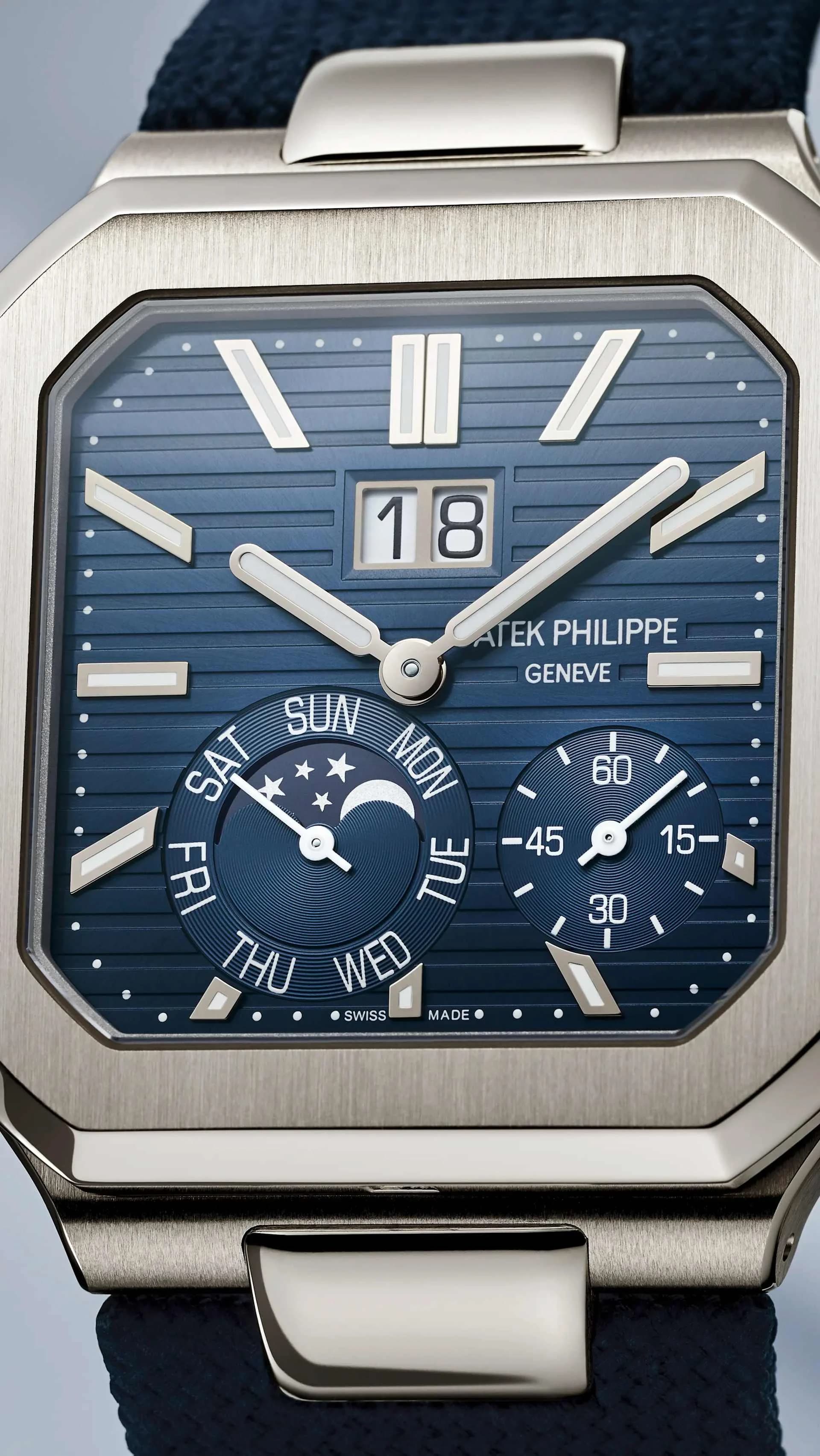 reloj de caja cuadrada con esfera azul, fecha grande, día de la semana con fases lunares y contador de minutos, correa textil azul