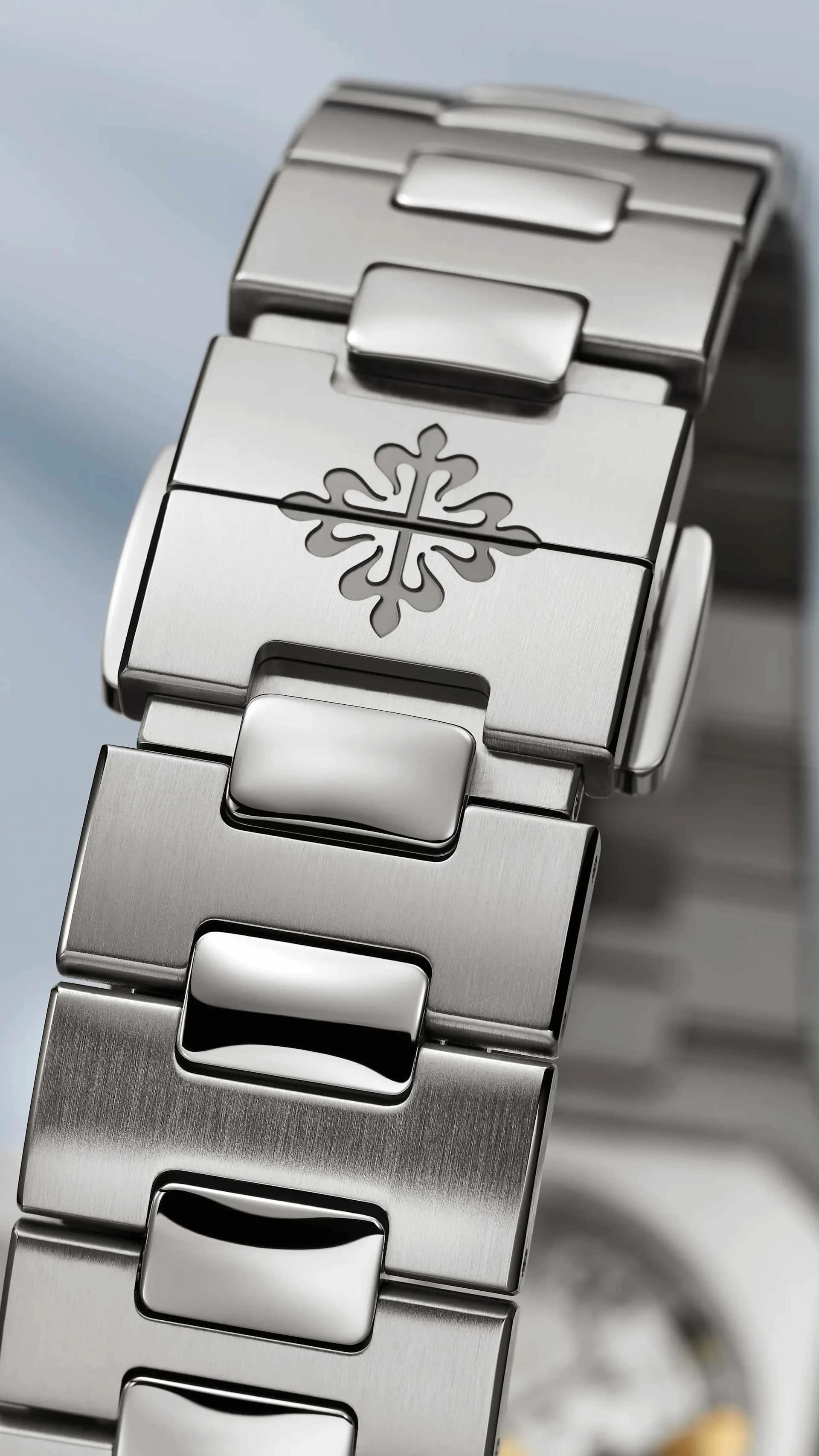 macro del brazalete metálico con un eslabón grabado con una cruz calada