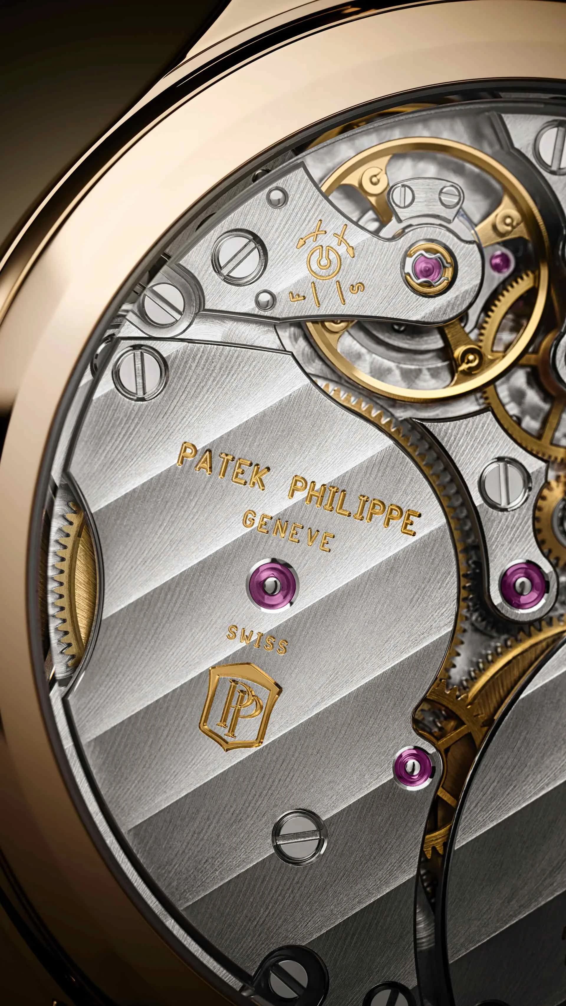macro del movimiento visto a través del fondo de cristal con el grabado Patek Philippe Geneve, rubíes rosados y puente decorado con acabado rayado, dentro de una caja de tono dorado
