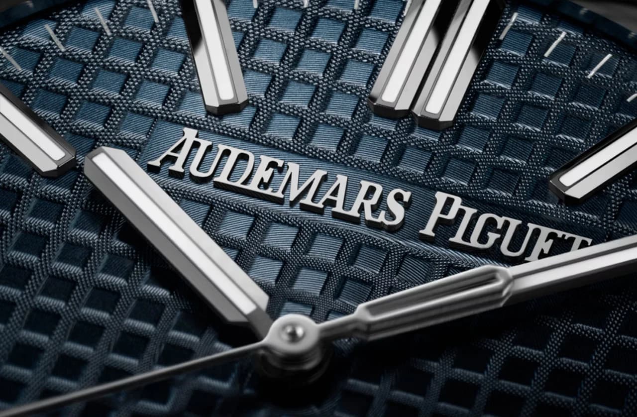 macro de la esfera azul con textura de motivo grande de Audemars Piguet mostrando el logotipo, los índices facetados y las manecillas