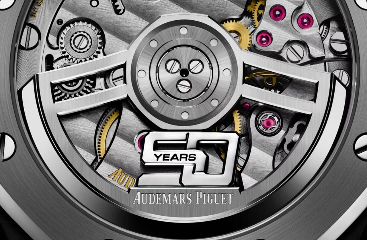 macro del movimiento visto a través del fondo de cristal con puente en forma de estrella, tornillos rosas y grabado conmemorativo de 50 años y Audemars Piguet