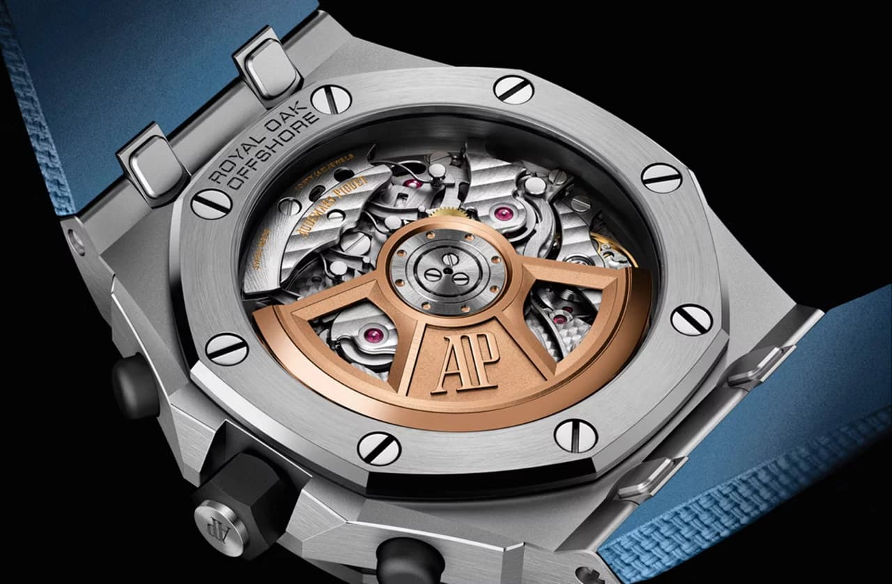 fondo de caja transparente de un reloj Royal Oak Offshore mostrando el movimiento con masa oscilante dorada grabada con las iniciales AP, caja de acero con bisel octagonal atornillado y correa azul
